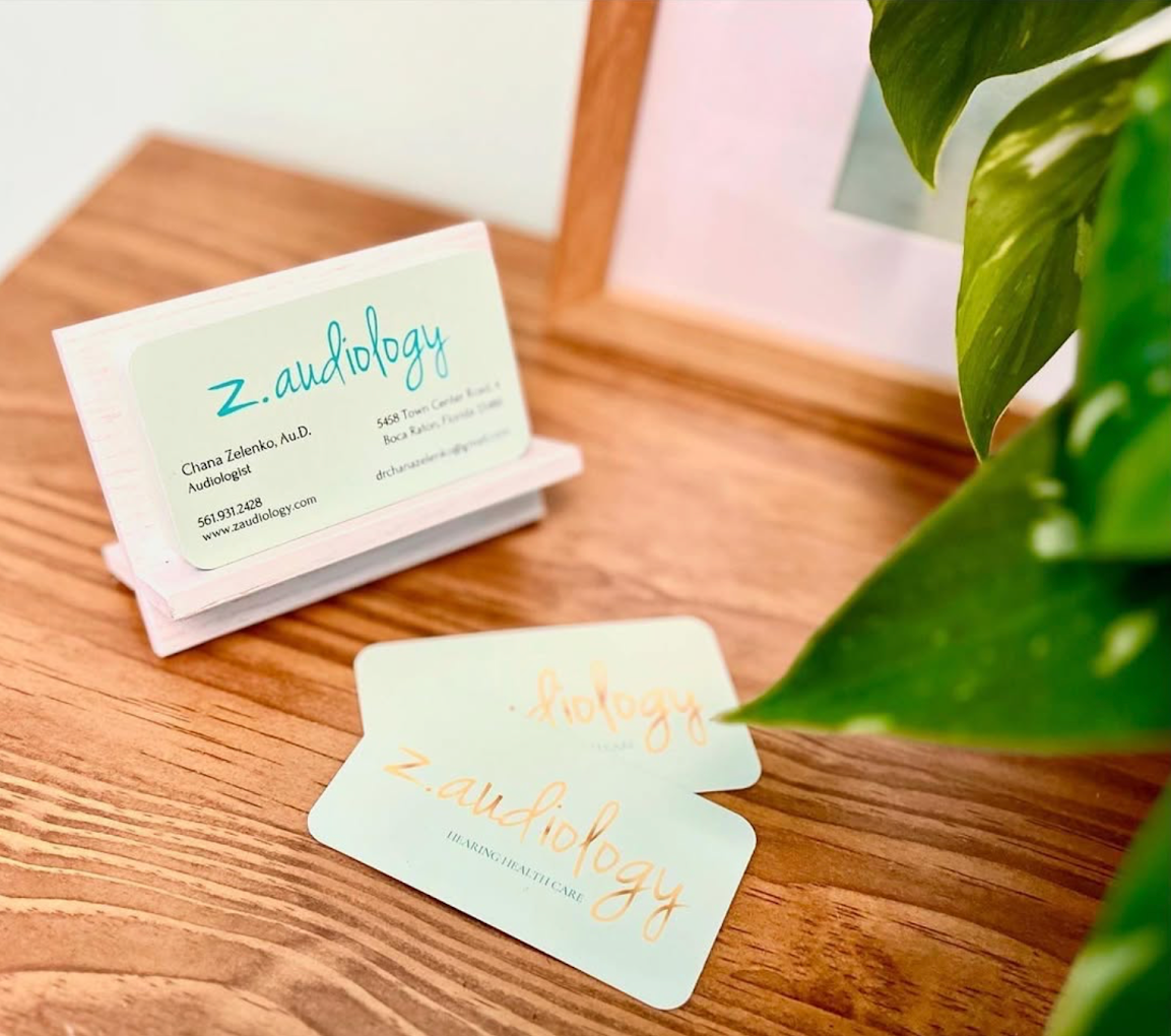 z.audiology business cards on a light oak surface